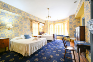 two beds, window seat, desk, bureau shown as example of second floor room