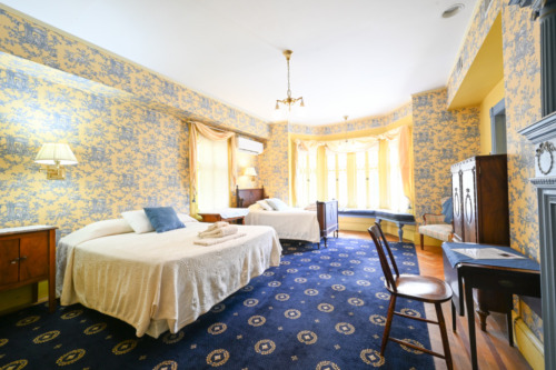 two beds, window seat, desk, bureau shown as example of second floor room