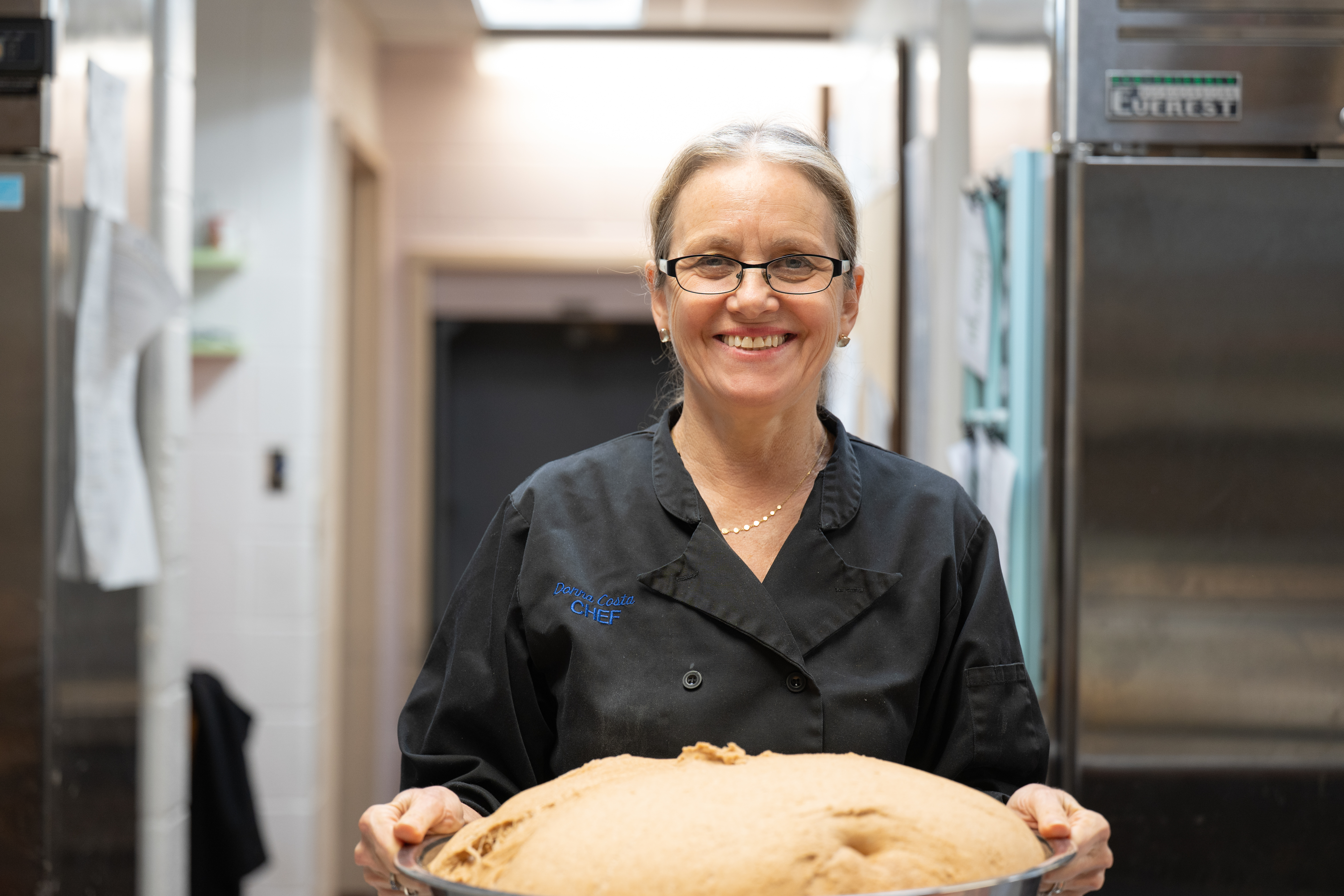 Chef Donna smiling, holding some freshly baked Stony Point Center bread